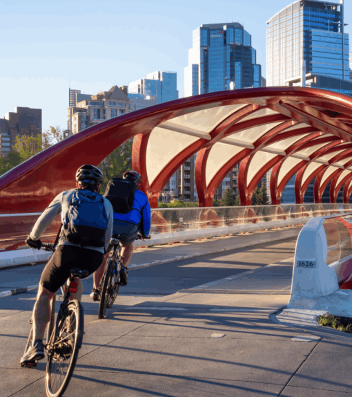 Two cyclists ride onto the Peace Bridge in Calgary